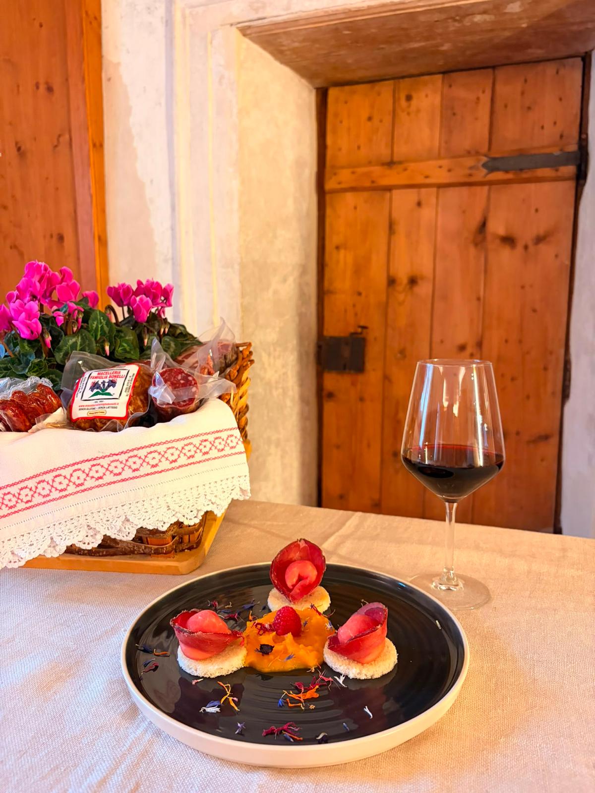 Tavola imbandita con antipasto, salumi e calice di vino